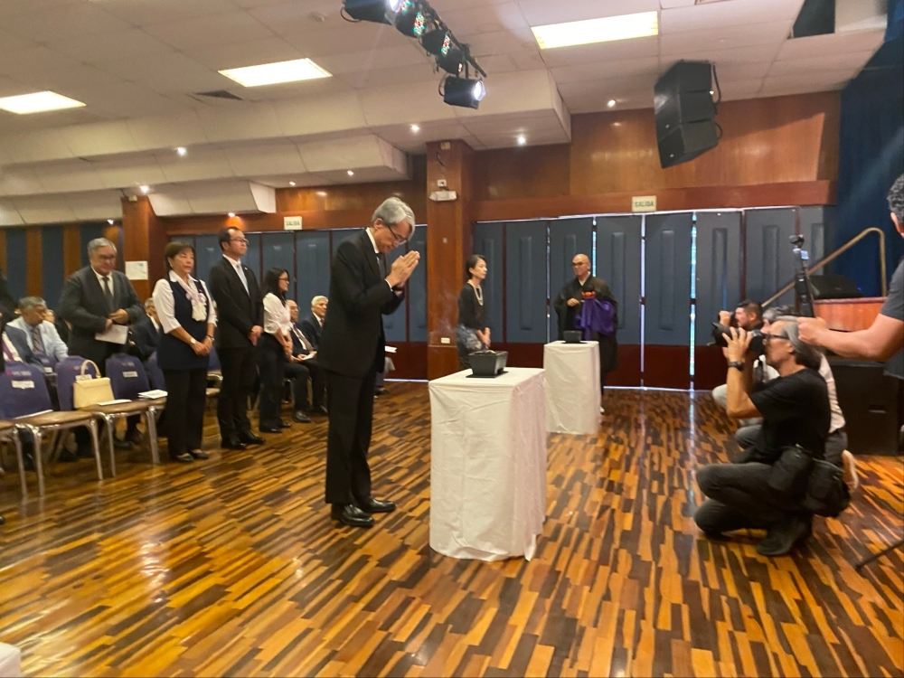 El embajador YAMAMOTO juntando sus manos durante la ceremonia.