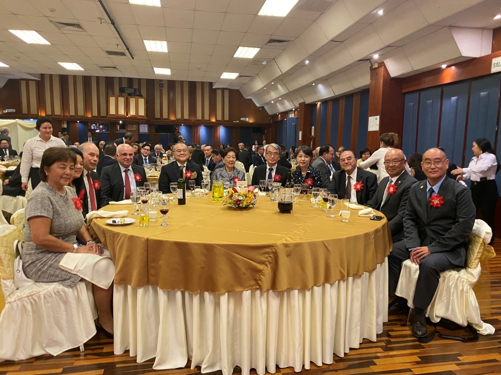 Participación del embajador YAMAMOTO y su esposa, El embajador del Perú en el Japón, señor Tenya, y otros asistentes, alrededor de la mesa